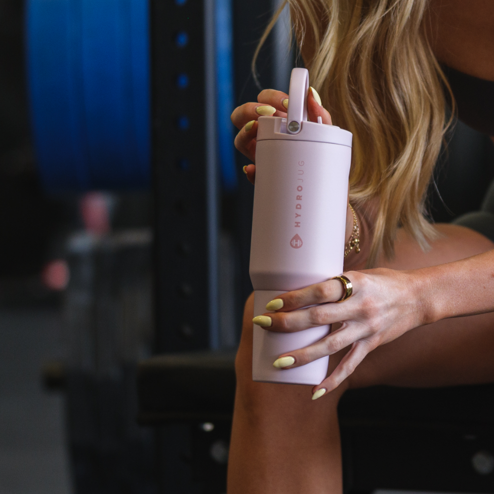 Person Holding Tradeons Pink Sand Sport Bottle 20oz at Gym